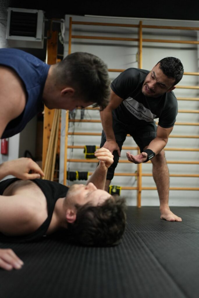 Marco Tulio Flavio corregint una tècnica a dos alumnes de BJJ a Andorra